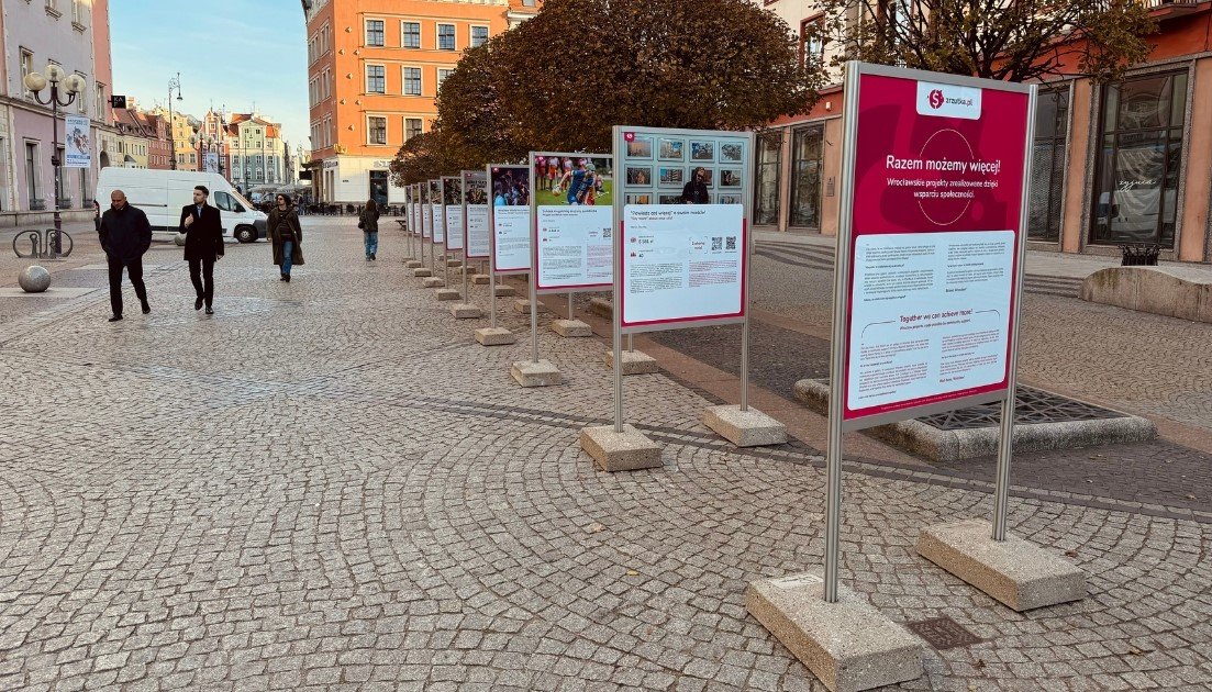 Na zdjęciu ujęcie wystawy na ulicy Świdnickiej we Wrocławiu. Dobrze widoczna jest pierwsza, różowa tablica z tytułem wystawy